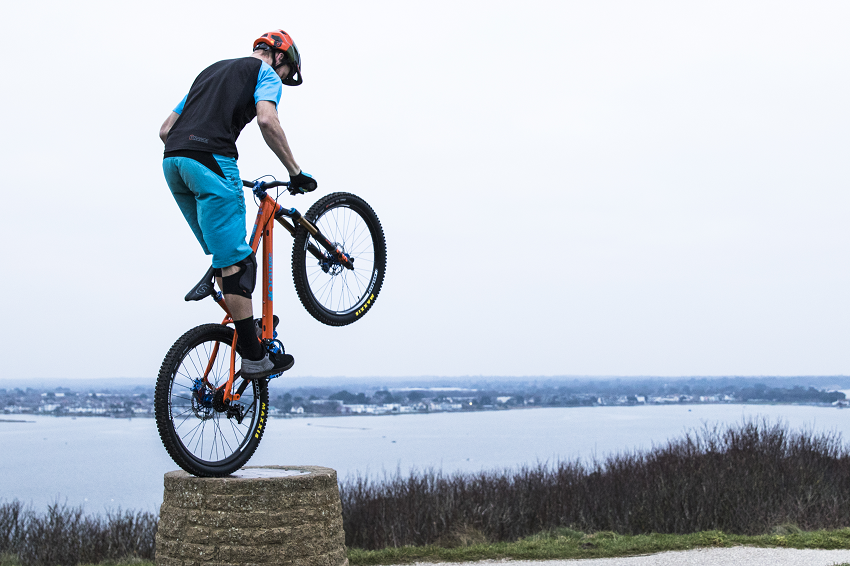 Ben Moore doing balancing on his bike's back wheel at Hengistbury Head 